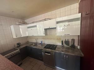 a kitchen with white cabinets and a counter top at Бордуляка 11 in Ternopil