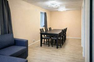 a dining room with a table and chairs and a couch at Hel hus i rolig by in Birkelse