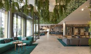 a lobby with blue couches and tables at Hyatt Regency Amsterdam in Amsterdam