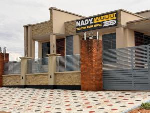 a building with a sign in front of it at Nadyapartment in Dodoma