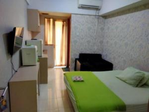 a room with a bed and a desk with a television at Japlen Room in Pondokcabe Hilir