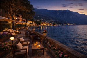 a restaurant with tables and chairs next to a body of water at Boutique Hotel Bogliaco in Gargnano