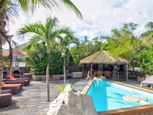 a pool at a resort with palm trees at Les Cottages Couleur Café in Cul de Sac