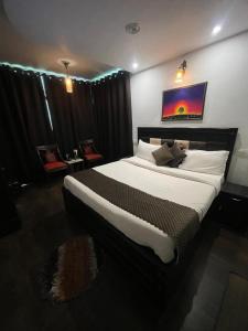 a large bed in a room with black drapes at Upper city heart hotel #Atithi Devo Bhava #Mountain View # Cheap Hotel Best Prices Guaranteed with Deals#Free Parking#cricket stadium 8 km#Mcleodganj 2 km- Bhagsunag 4 km in Dharamshala