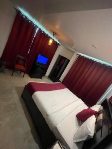 a bedroom with a large bed with red curtains at Upper city heart hotel #Atithi Devo Bhava #Mountain View # Cheap Hotel Best Prices Guaranteed with Deals#Free Parking#cricket stadium 8 km#Mcleodganj 2 km- Bhagsunag 4 km in Dharamshala