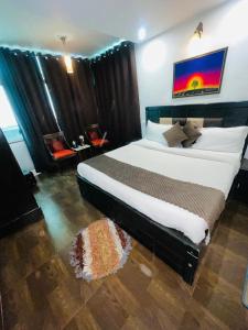 a bedroom with a large bed in a room at Upper city heart hotel #Atithi Devo Bhava #Mountain View # Cheap Hotel Best Prices Guaranteed with Deals#Free Parking#cricket stadium 8 km#Mcleodganj 2 km- Bhagsunag 4 km in Dharamshala +1 photo