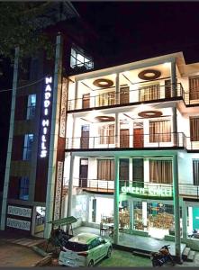 a building with a car parked in front of it at Upper city heart hotel #Atithi Devo Bhava #Mountain View # Cheap Hotel Best Prices Guaranteed with Deals#Free Parking#cricket stadium 8 km#Mcleodganj 2 km- Bhagsunag 4 km in Dharamshala
