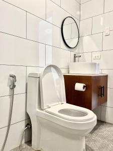 a white bathroom with a toilet and a mirror at Lunara Villas in El Nido