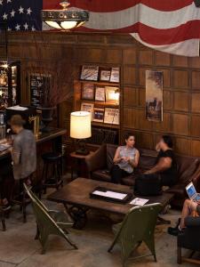 a group of people sitting on couches in a bar at Ace Hotel New York in New York