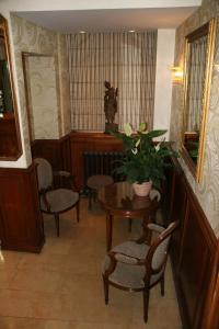 a room with chairs and a table with a potted plant at Hotel Bellevue Saint-Lazare in Paris