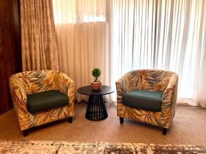 two chairs and a table in a room with a window at Flamingo on Korsman in Benoni
