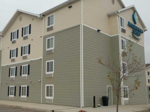 un grande edificio con un cartello sul lato di WoodSpring Suites Williston a Williston