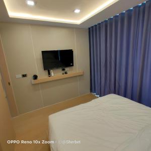 a bedroom with a bed and a flat screen tv at Luxtalay Space Capsule in Ban Thung Makham