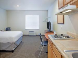 una camera d'albergo con letto e cucina con lavandino di WoodSpring Suites Williston a Williston