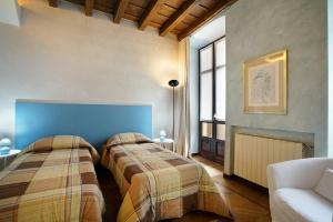 1 dormitorio con 2 camas y 1 sofá en una habitación en Casa Marta, en Bérgamo