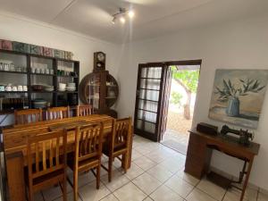 a dining room with a wooden table and chairs at Manasseh in Riversdale