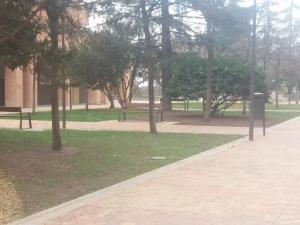 a park with benches and trees and a building at The office 2020 in Tres Cantos