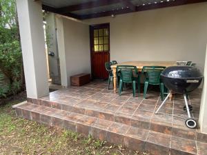 a patio with a bbq and a table and chairs at Manasseh in Riversdale