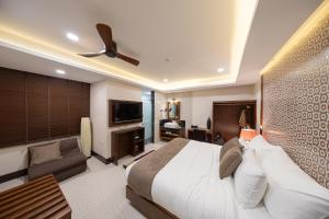 a bedroom with a large bed and a living room at Casa Le Damuz At MRT Bangphlat - Adult Only in Bangkok