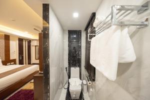 a bathroom with a shower and a bed and towels at Casa Le Damuz At MRT Bangphlat - Adult Only in Bangkok +97 photos