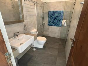 a bathroom with a sink and a toilet and a shower at Linará in Hikkaduwa