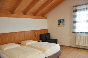 a bedroom with a bed and a chair in it at Hotel Alber in Marktl