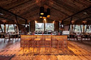 a bar in a restaurant with chairs and tables at Lamia Bamboo Retreat Ninh Binh in Ninh Binh
