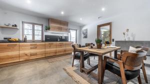 a kitchen and dining room with a wooden table and chairs at Naturhaus Leger in Lenggries
