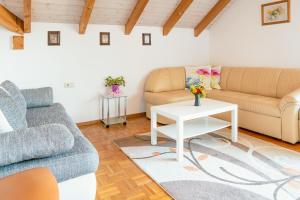 a living room with two couches and a table at Armonia Altach, 2BR Familienapartment mit großem Balkon und Bergblick in Altach