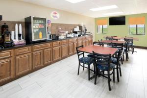 un restaurante con mesas y sillas y una cafetería en Super 8 by Wyndham Charleston Sikeston East MO, en Charleston