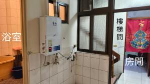 a bathroom with a window and a tiled wall at 山頂洞人 in Fengyuan