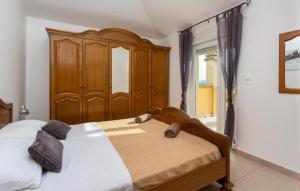 a bedroom with a large bed with a wooden headboard at Villa Sbay in Omišalj