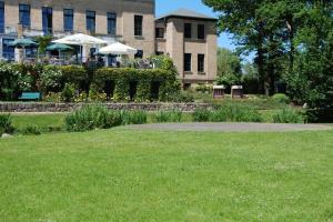 um parque com uma mesa e cadeiras num edifício em Gutshaus Redewisch Hotel & Restaurant em Boltenhagen