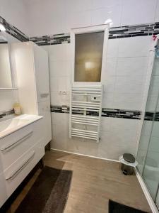 a white bathroom with a sink and a window at gîte 65 m2 200 m gare t-g-v et fac 400 m centre-ville grand parking 250 places gratuit face au logement in Arras +18 photos