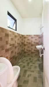 a bathroom with two toilets and a sink and a window at Coconut El Nido in El Nido
