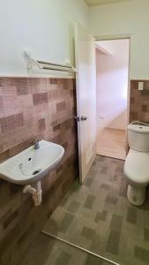 a bathroom with a sink and a toilet at Coconut El Nido in El Nido