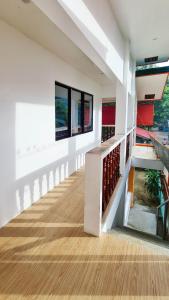 a hallway of a house with white walls and wooden floors at Coconut El Nido in El Nido +9 photos