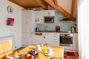 a kitchen with a table with fruit on it at Armonia Altach, 2BR Familienapartment mit großem Balkon und Bergblick in Altach