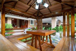 a wooden deck with a wooden table on it at The Phuket Pool Villa in Phuket