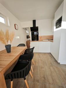 a kitchen with a wooden table and black chairs at Bambou Zen Room in Rang-du-Fliers
