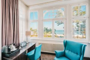 a room with a desk and chairs and windows at Hotel Villa Belvedere in Binz