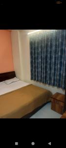 a bedroom with two beds and a window at Blue Sapphire in Hinjewadi