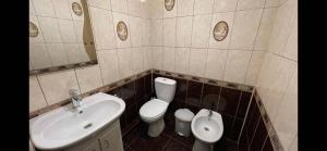 a bathroom with a sink and a toilet and a mirror at Ciocana in Chişinău