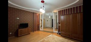 a living room with a tv on a dresser and a hallway at Ciocana in Chişinău