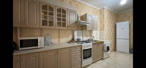 a kitchen with wooden cabinets and a white refrigerator at Ciocana in Chişinău