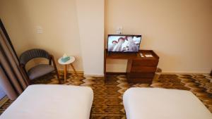 a room with two beds and a tv and a chair at The View Luxor hotel in Luxor