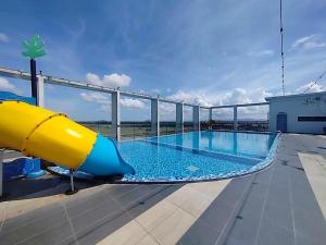 a pool on the roof of a building with a slide at Wafiq Studio in Kota Bharu