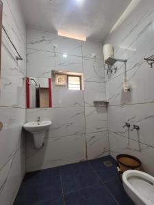 a white bathroom with a sink and a toilet at EVA AYURVEDIC beach hotel in Varkala