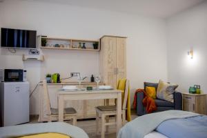 a small living room with a table and a kitchen at Hont Vendégház in Hont