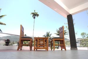 a group of chairs sitting on top of a porch at Budget Appartments Thekkady in Thekkady